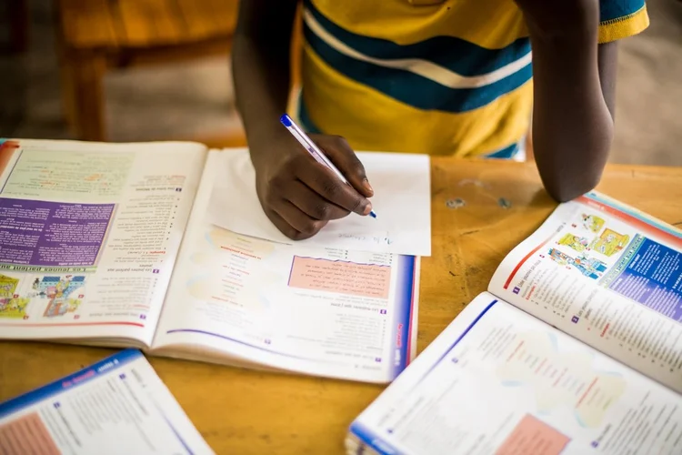 African Neurodiversity Movement A learner writing beside open school books