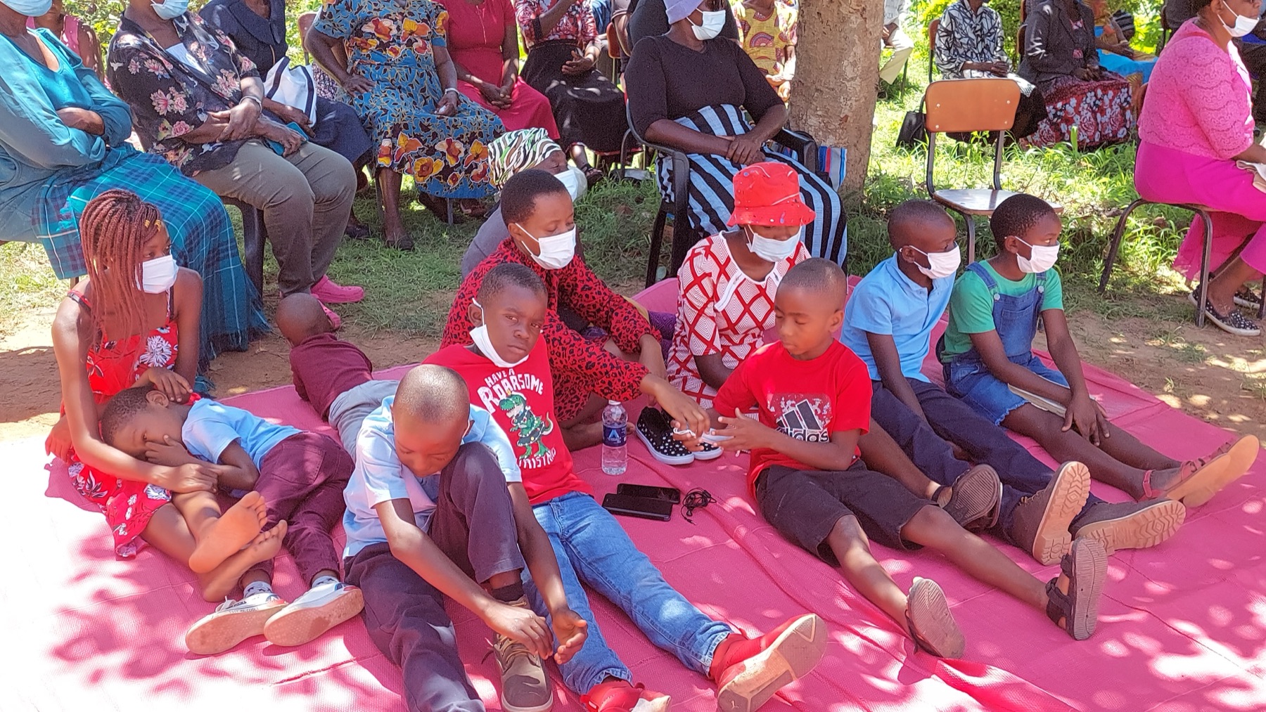 African Neurodiversity Movement African children and adults gathered under trees at a community event