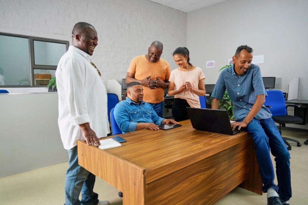 A group of African colleagues sharing ideas around a laptop