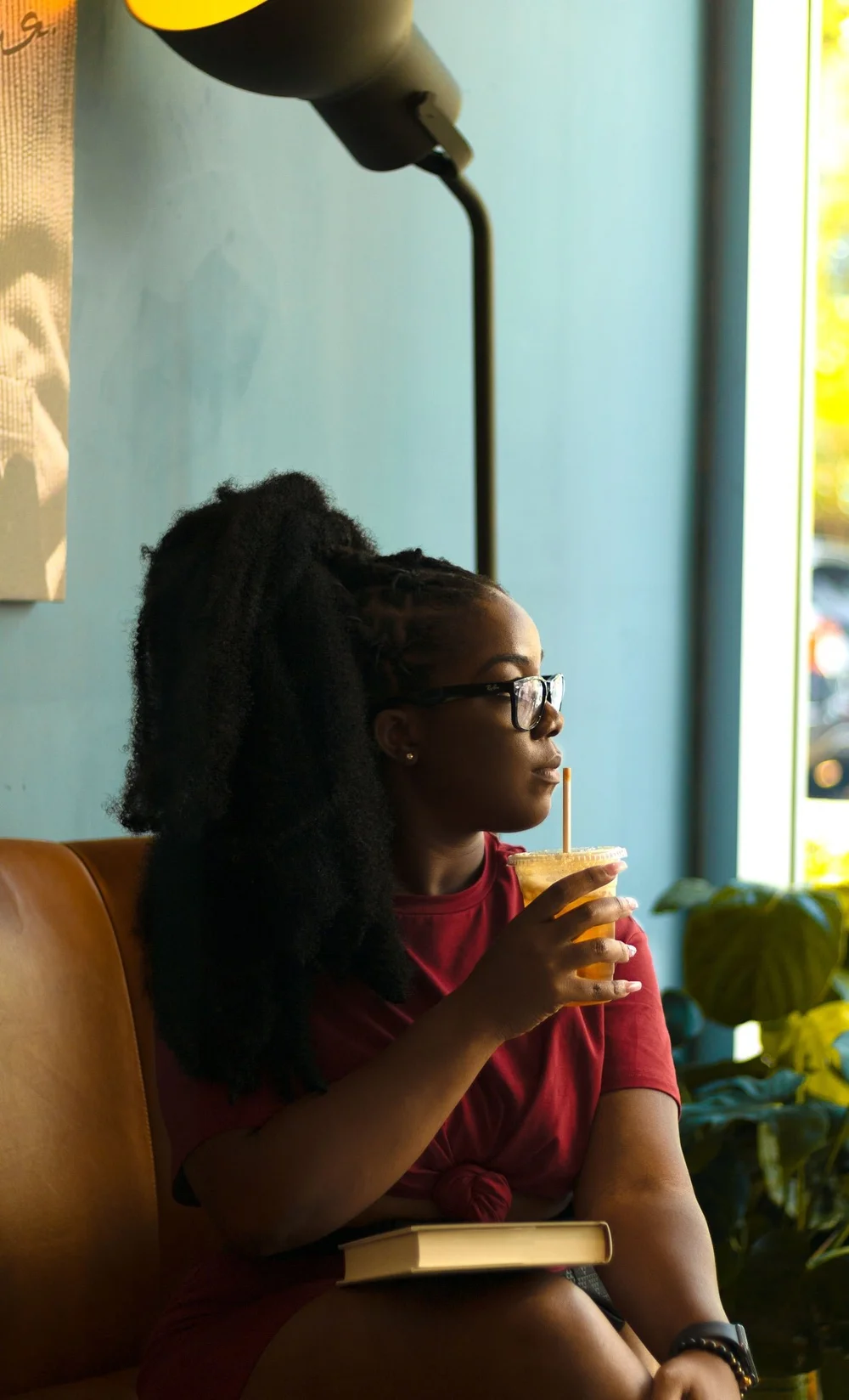 Programs & Training A Black woman with glasses seated in a calm café setting