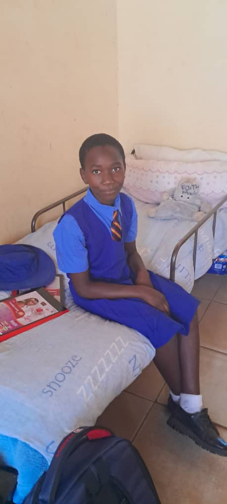 Programs & Training A school pupil sitting on a bed in school uniform