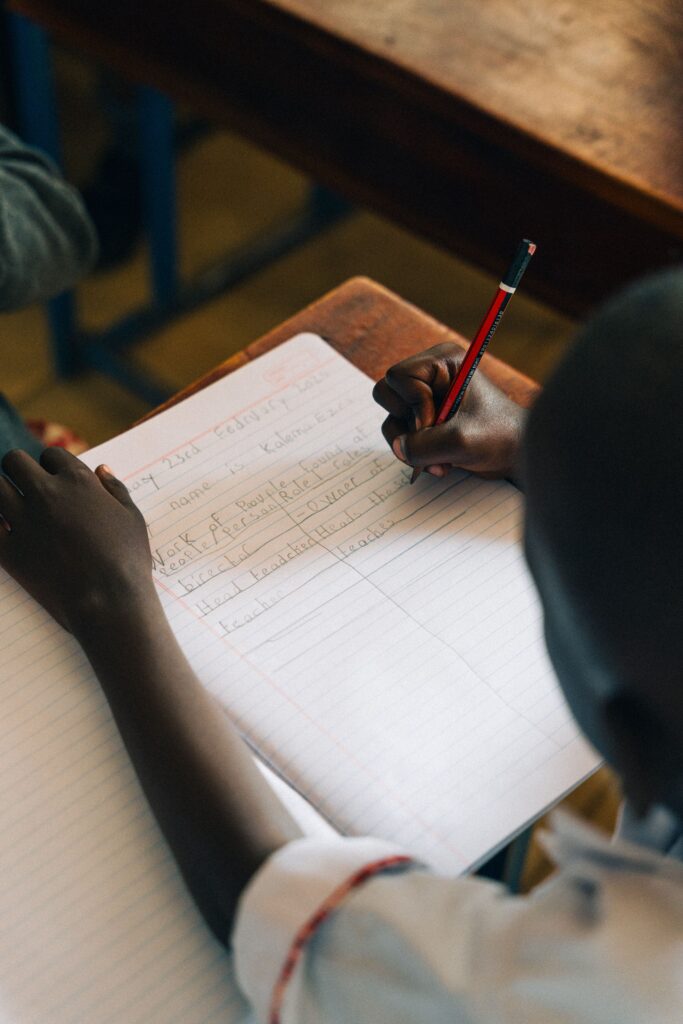 African Neurodiversity Movement A child diligently writes in a notebook at school, focusing on learning tasks.